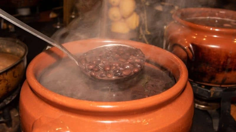 Concha separando feijão não queimado de porção queimada no fundo