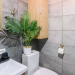 Banheiro moderno com elementos naturais, luz suave e design minimalista, tendência em banheiros 2025.